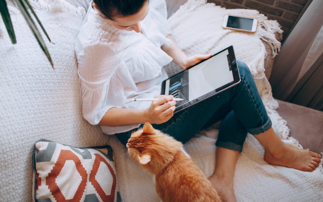 Woman computing on tablet with a cat