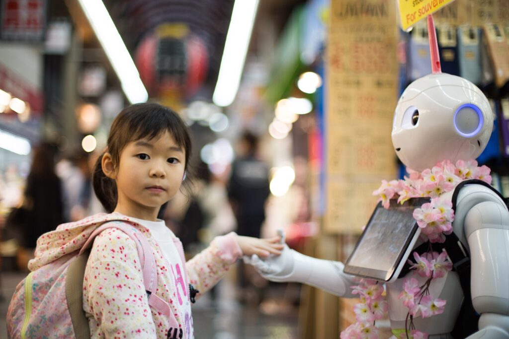 A young girl holding the hand of a Robot